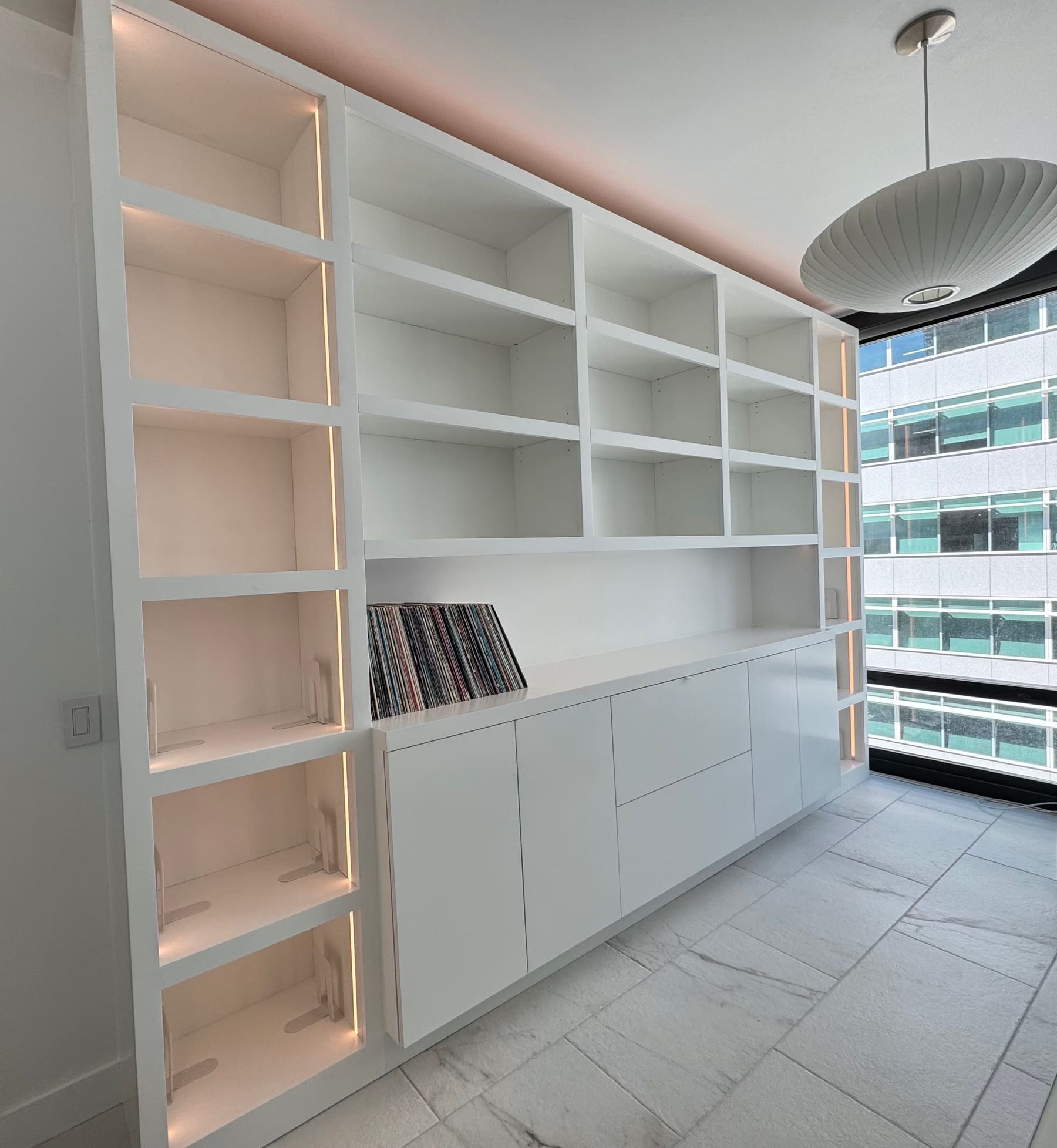 White painted built-in shelving wall with integrated lighting — Phoenix custom cabinetry
